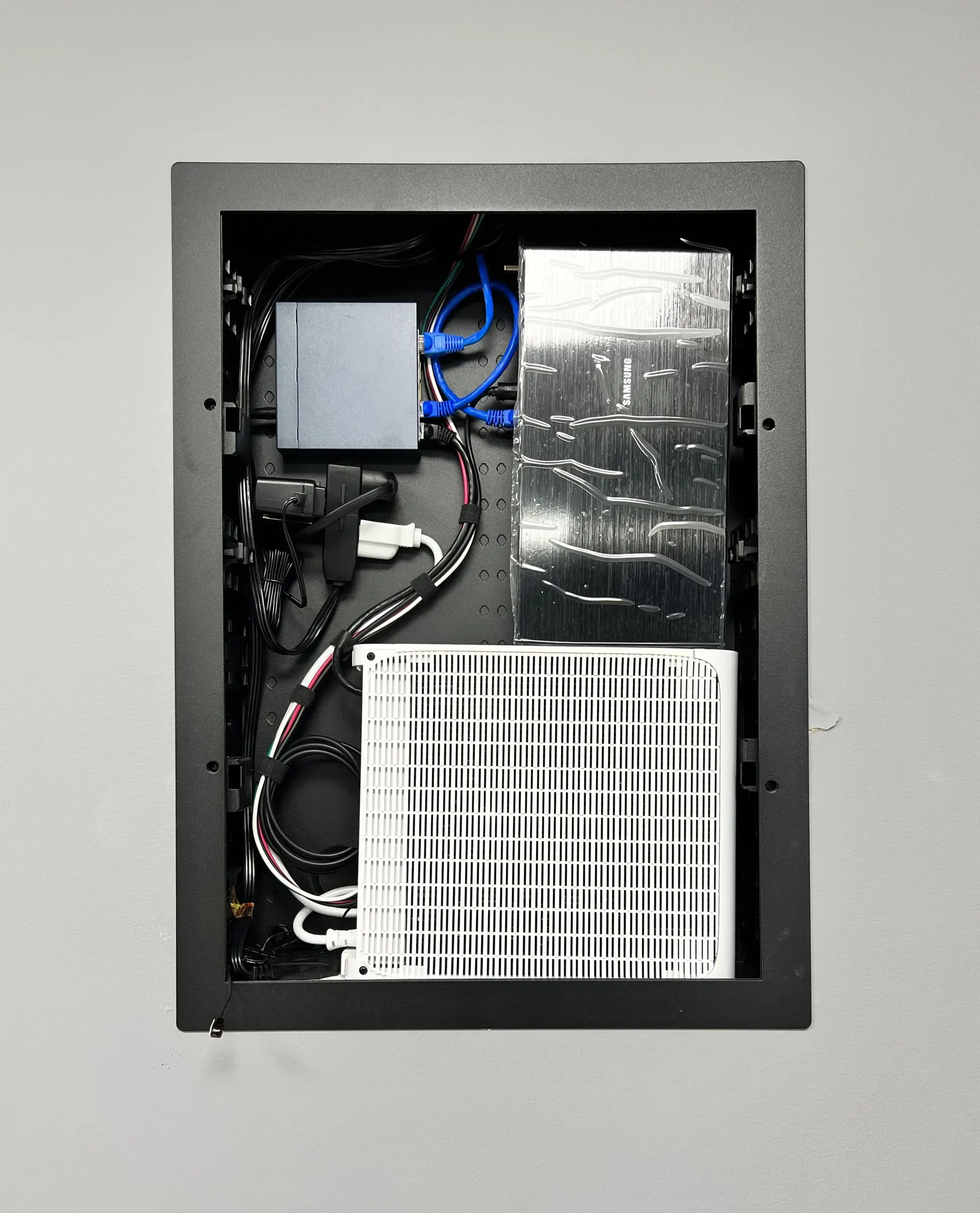 Open in-wall structured wiring enclosure with network hardware and neatly routed cables