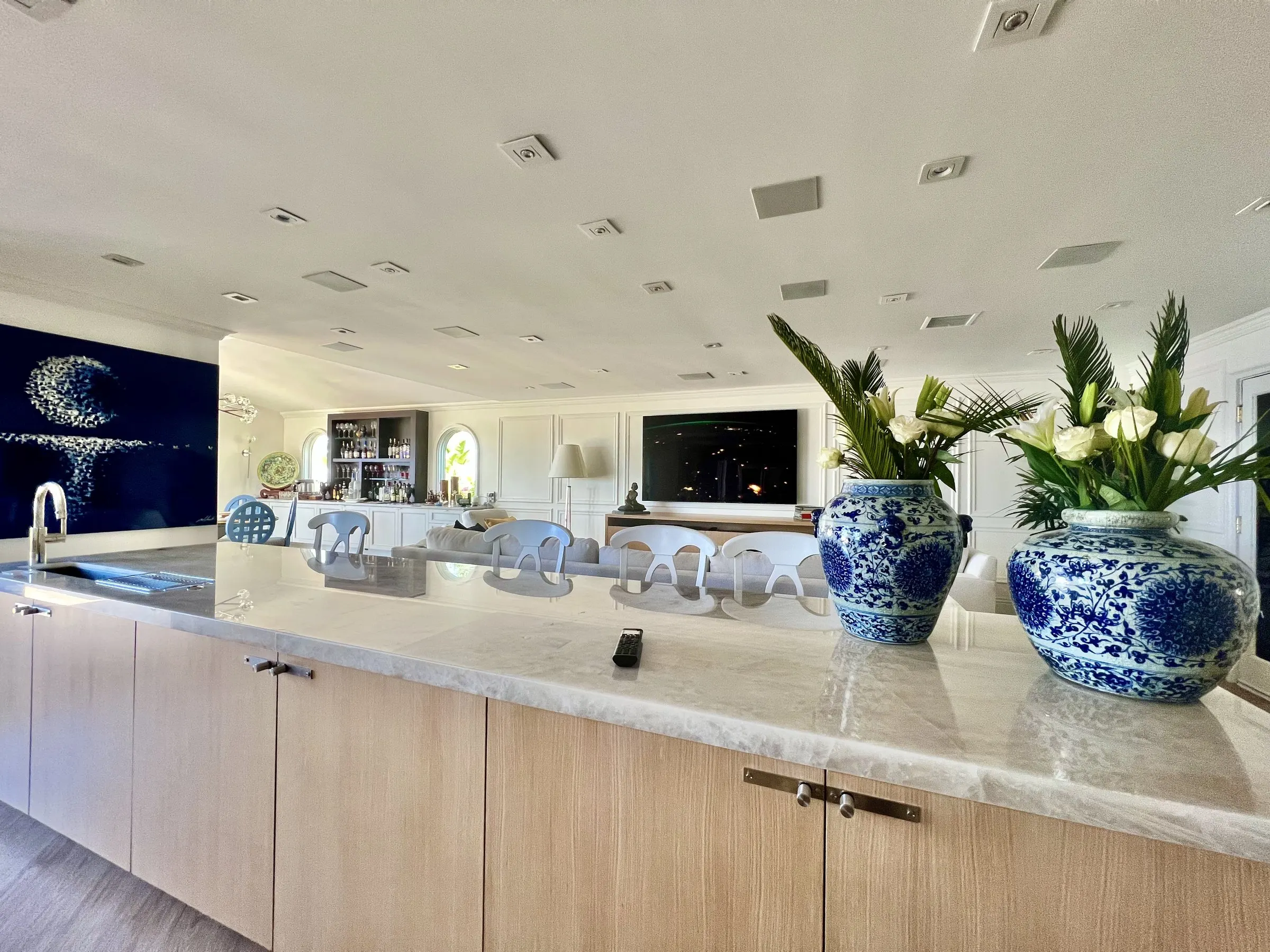 Open kitchen with blue and white vases and a display in the living area beyond