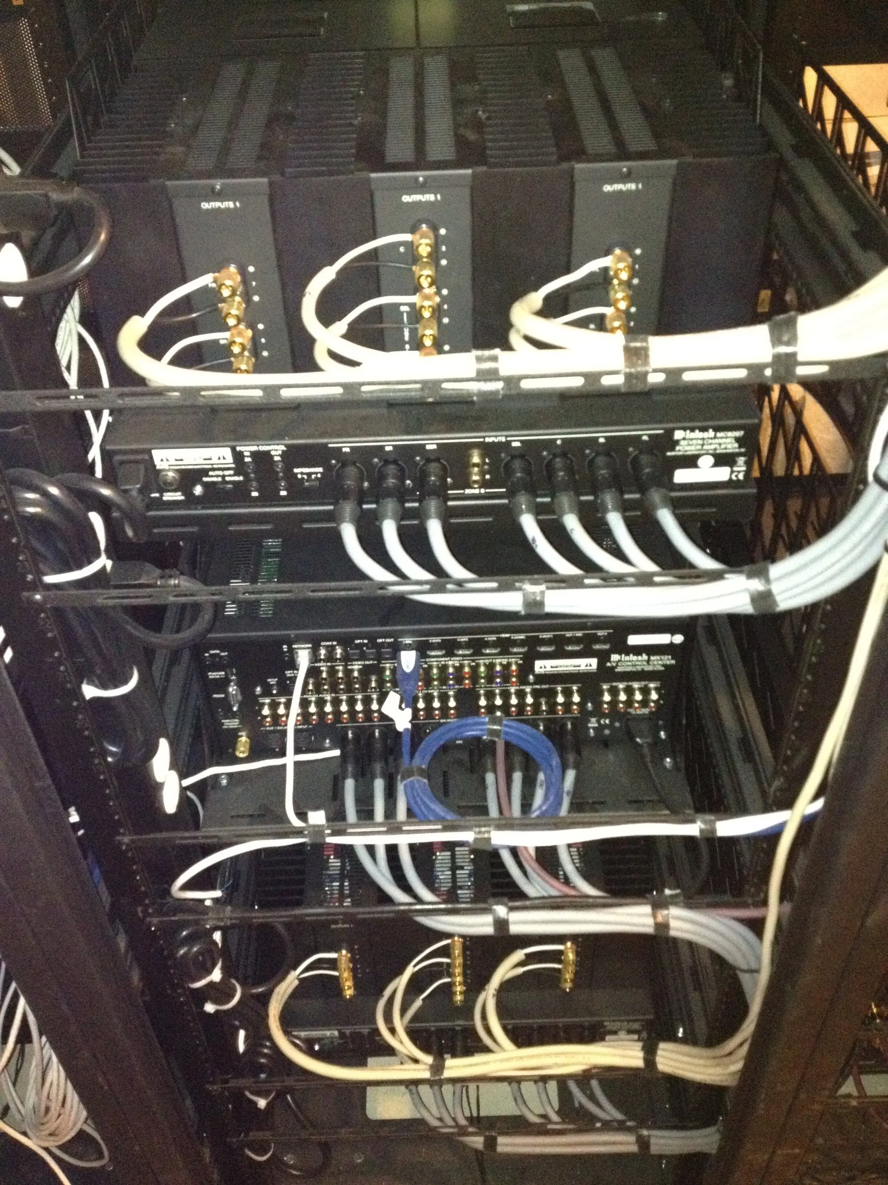 Back of an equipment rack with neatly dressed audio and network cabling