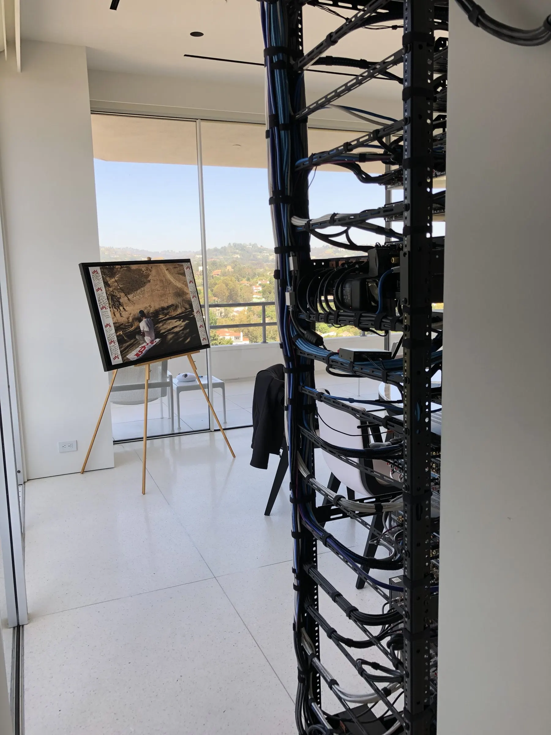 Close-up of vertical cable management on an equipment rack by a window
