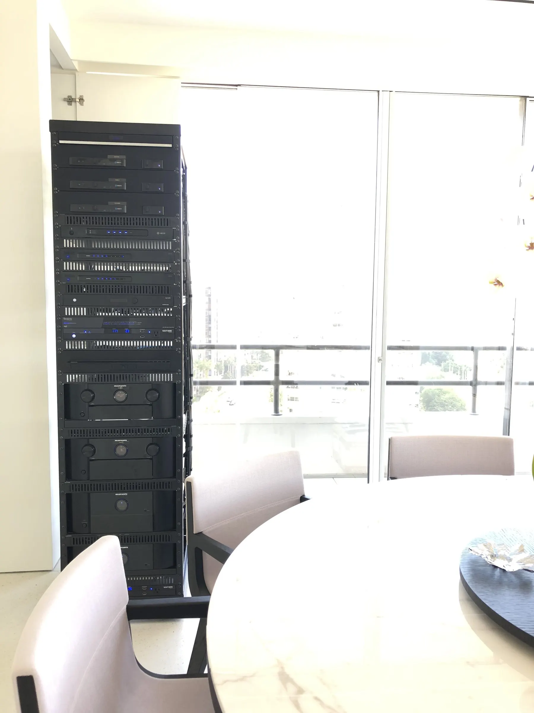 Equipment rack standing beside a round dining table with city views