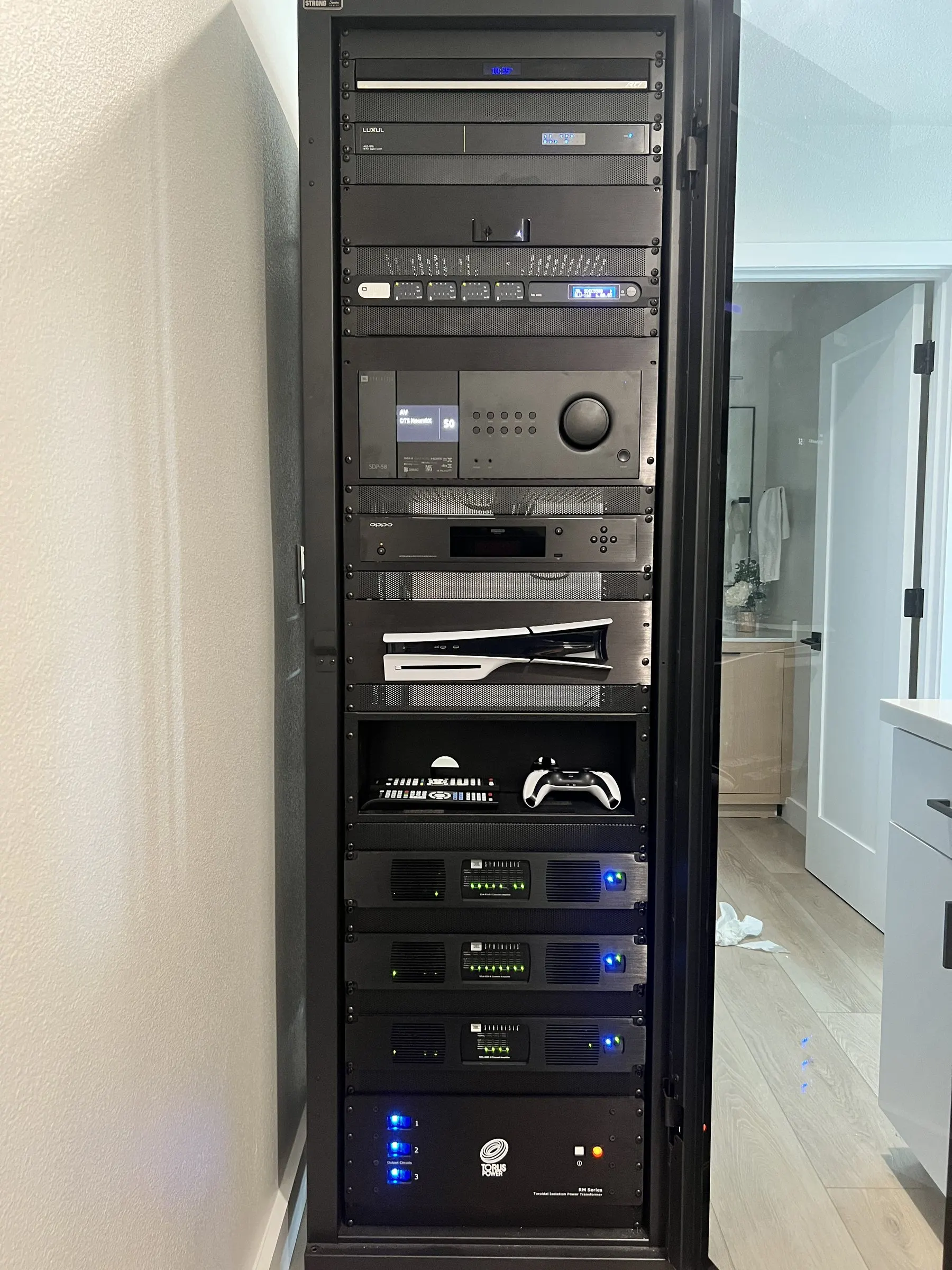 Front of an equipment rack with network, audio, and control components stacked neatly